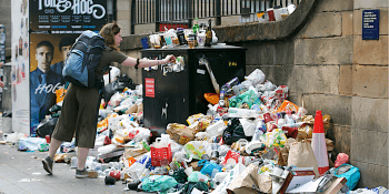 woman puts litter in overflowing bin in Edinburgh