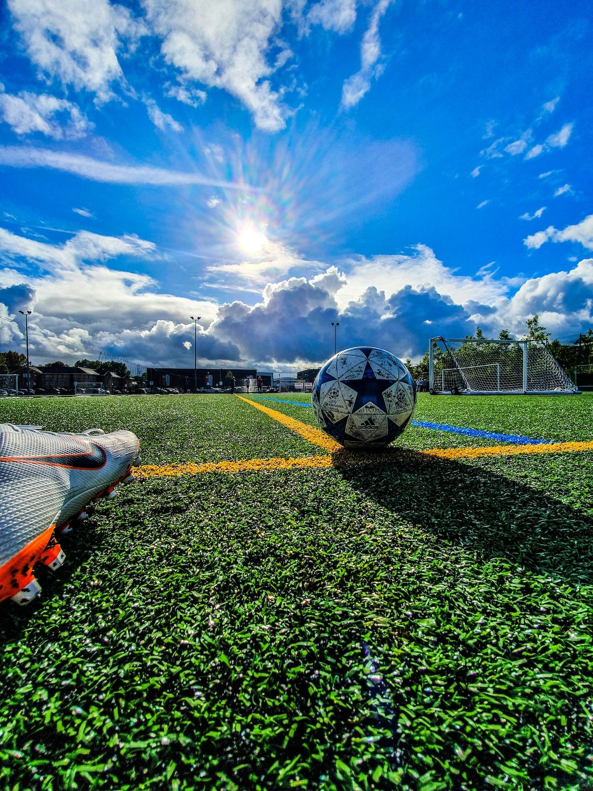 footballer's boot kicking a ball on an empty pitch